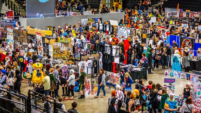 A bustling convention scene with diverse attendees in costumes, exploring various vendor booths filled with merchandise and art.