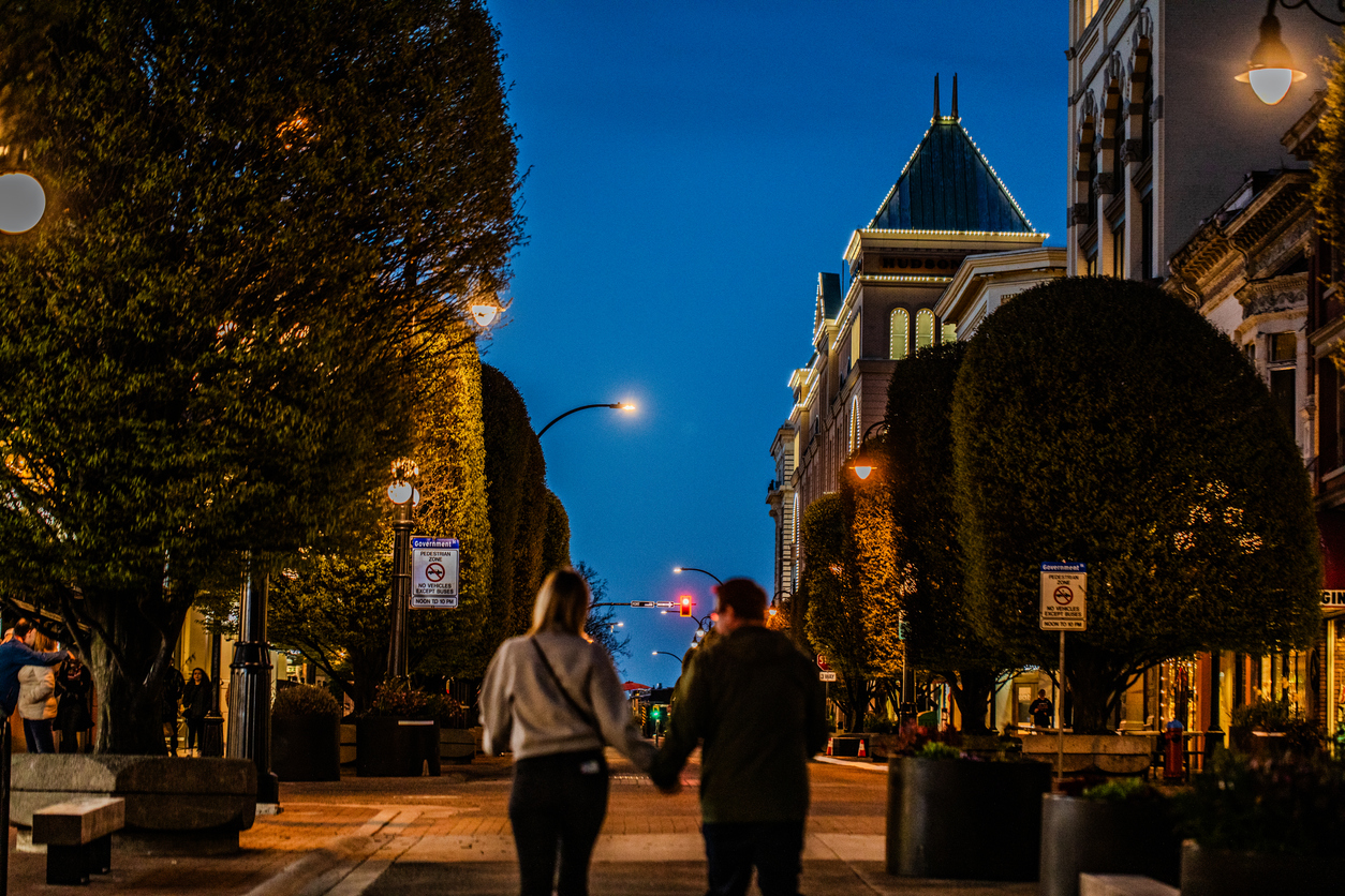 A couple Holding Hands walking on the streets, going for a date at nighttime